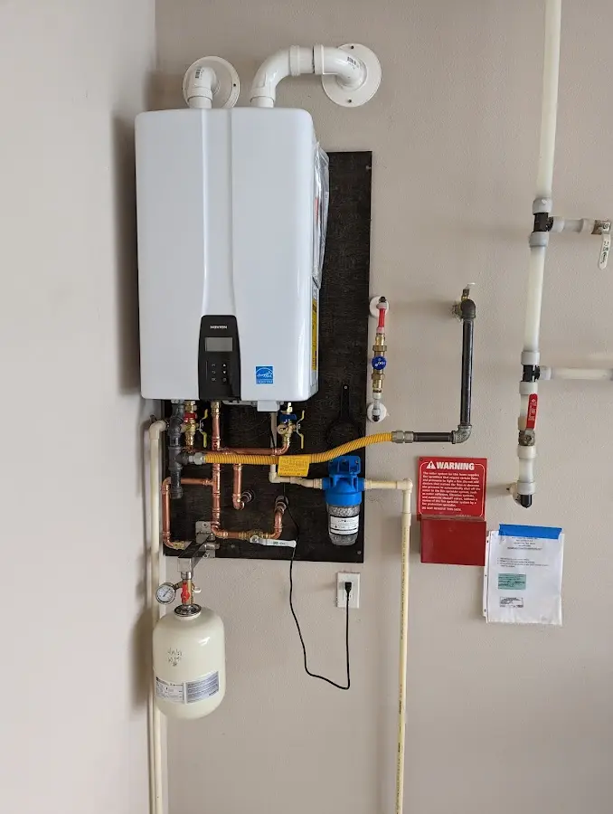 Professional plumber installing copper piping in a Holliston home